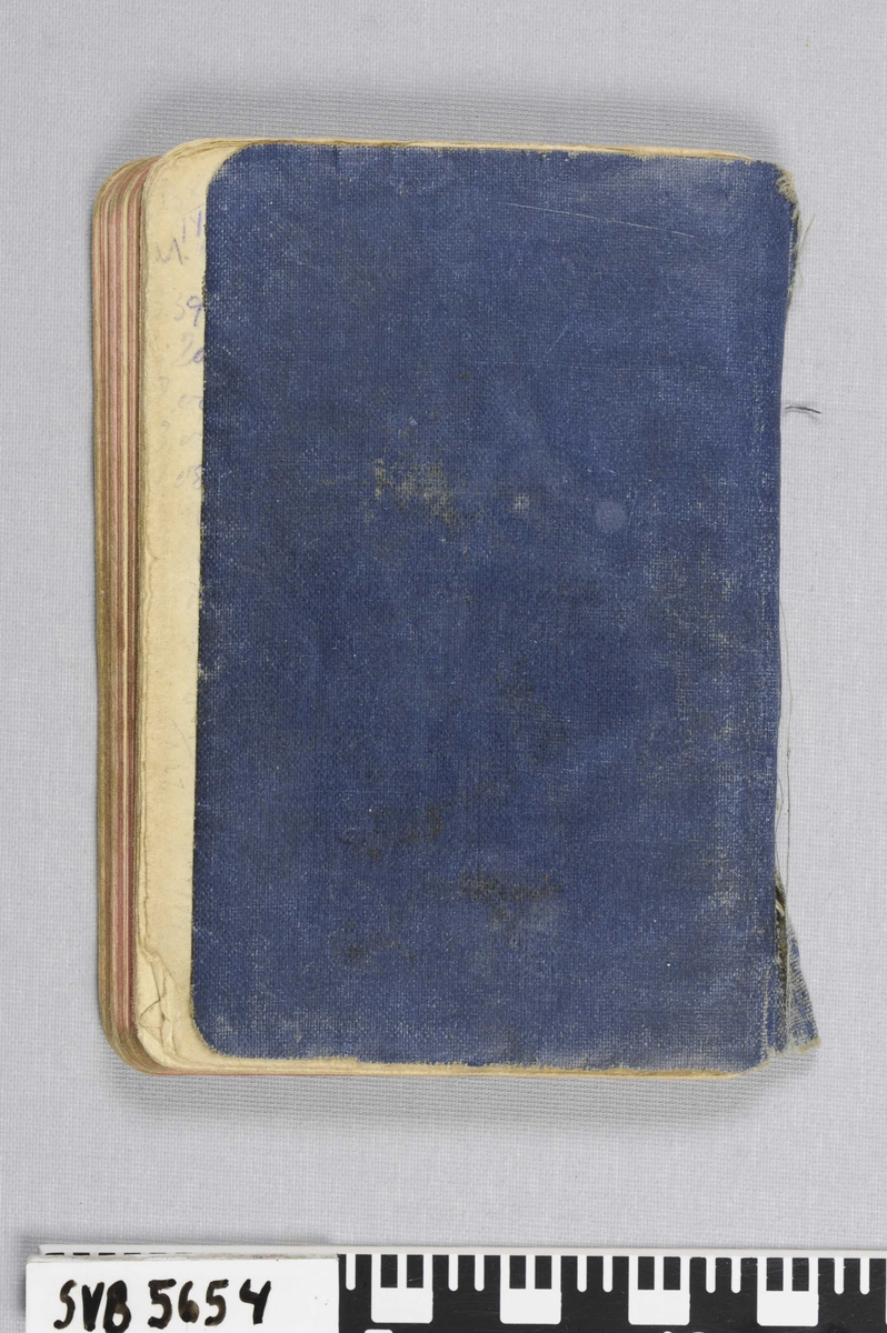 En bok med trykt tekst og håndskrevete notater, innbundet i lakkert tekstilomslag.