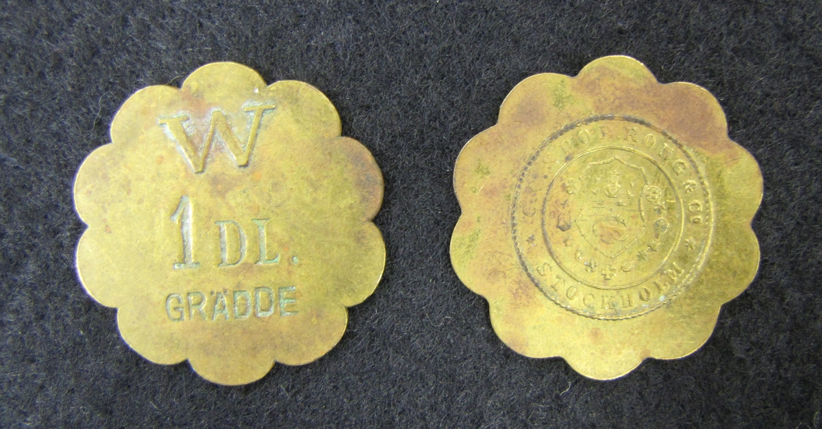 Två poletter i gulmetall . Varje polett motsvarade 1 deciliter grädde på Wargöns bruk AB.