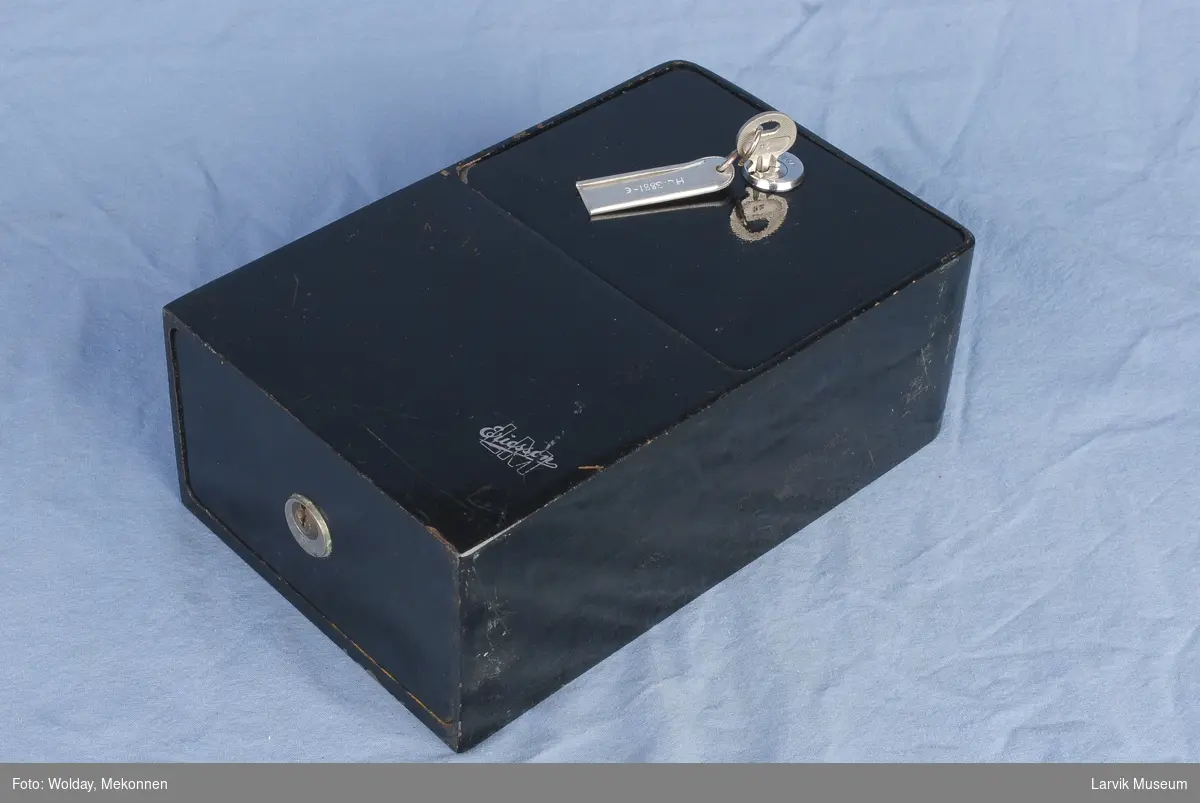 Form: Rektangulær boks m/myntinntak på topp, ,nøkkelhull m/nøkkel i front
uten telefondel men med bøsse og myntuts