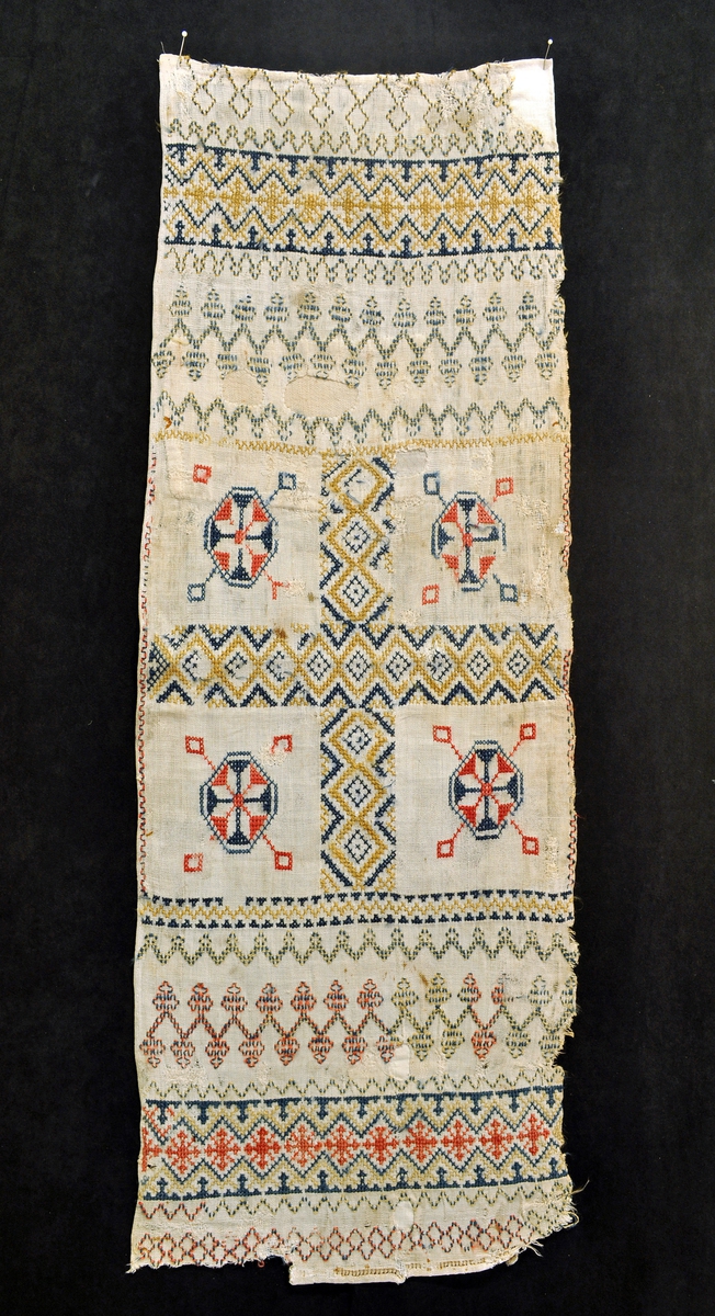 Fra protokollen: Gjelder begge, TGM-SM.2522.A og B: Krosklæde med sprang (firfletting), rikt (?), korssting, i Normannarænding.
Dette kledet har ikke noen fletter, har antagelig hatt det opprinnelig i den ene enden.