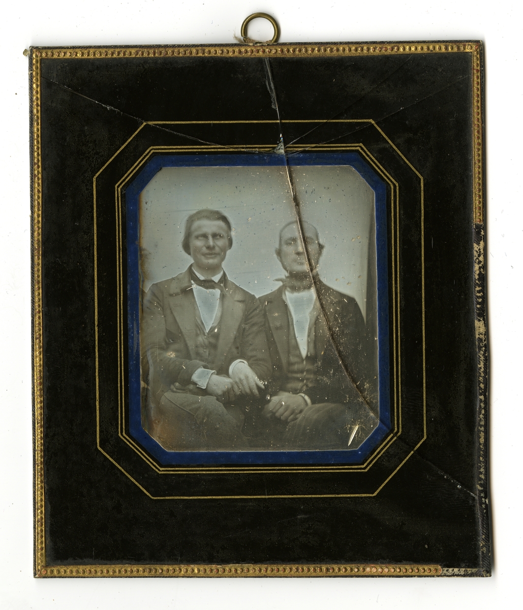 Daguerrotype av to unge menn fotografert sittende.