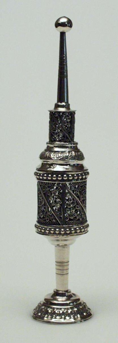 Røkeleseskar i sølv. Det har form som et lite tårn på sokkel med kule på toppen og rundt fotstykke med mønster. Karet er dekorert med perlerelieff og filigransmønster
