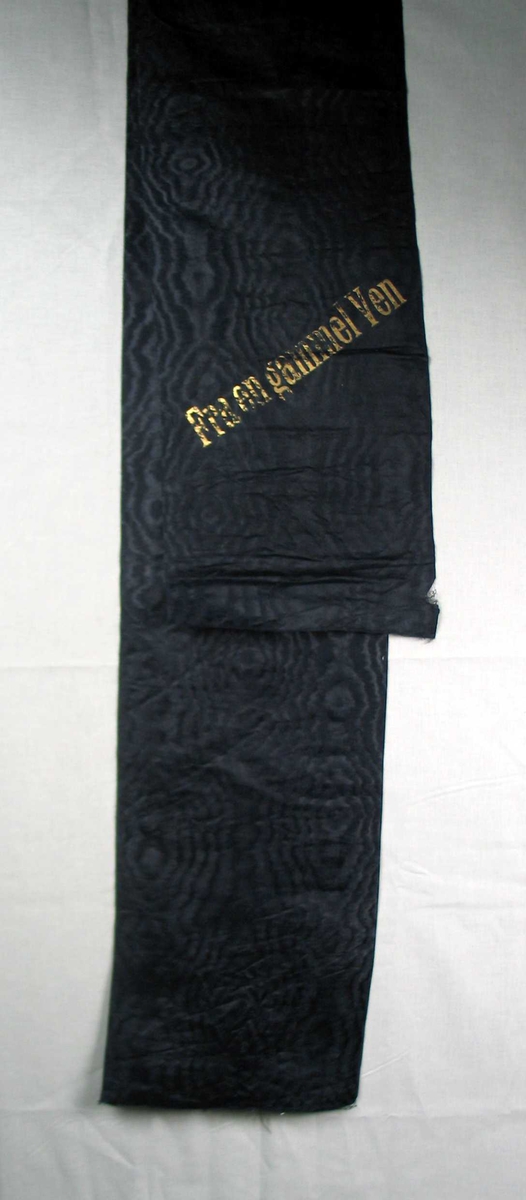Begravelsessløyfe i svart silke med tekst i gull.