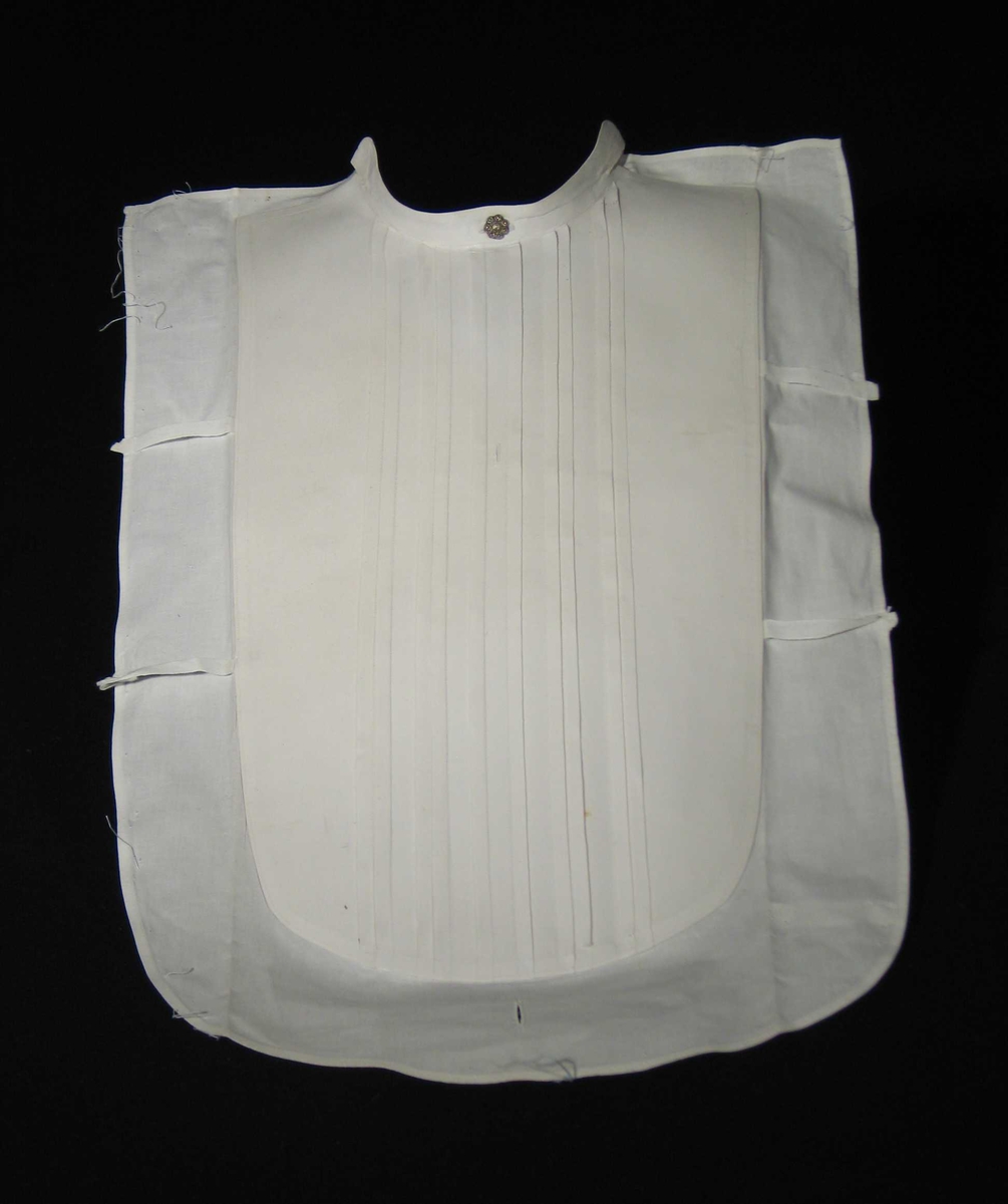 Hvitt stivet skjortebryst med metallknapp øverst, fem stukkede folder og hemper på sidene. Knapphull nederst.