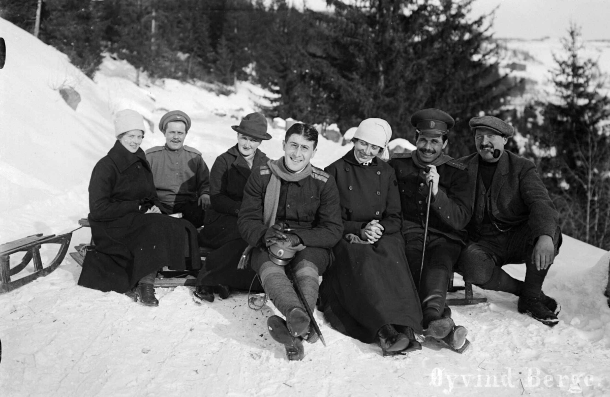 Gruppe med kvinner og menn med kjelker, to av mennene har uniform, ant. russiske offiserer, vinter 1917/1918. Ingeborg Øfsteng er nr. 3 fra venstre og Anders Øfsteng nr. 7 fra venstre