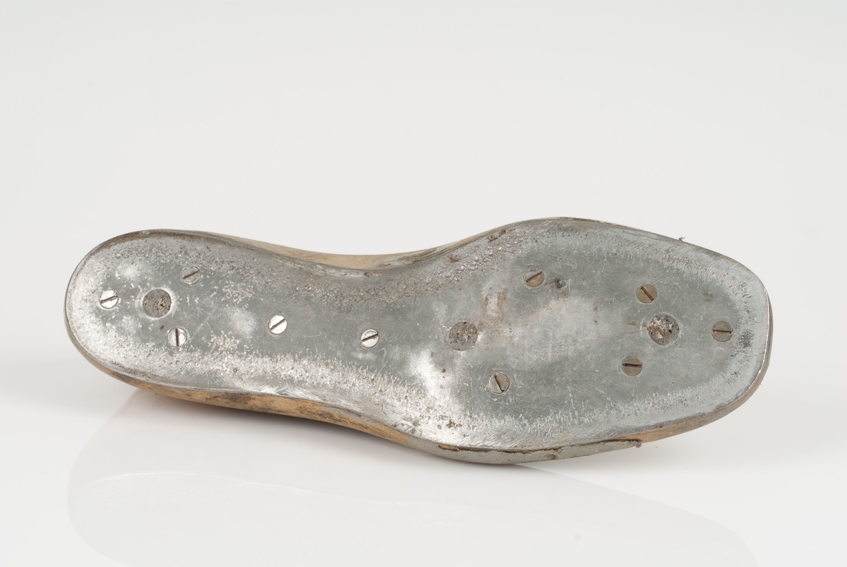 En tremodell i to deler; lest og opplest/overlest (kile).
Venstrefot i skostørrelse 42, og 8 cm i vidde.
Såle i metall.
