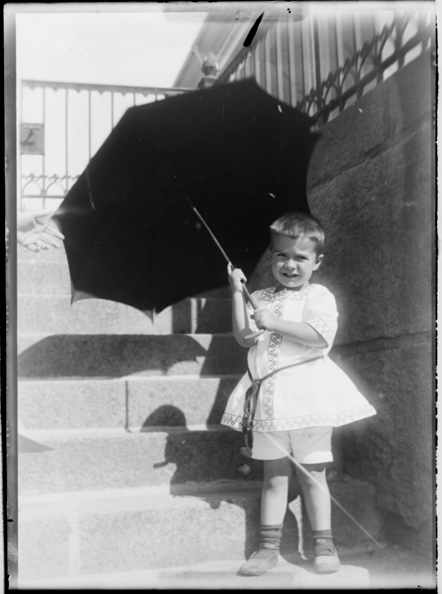 En liten gutt med en paraply i en trapp. Gutten er Wladimir Hansson.