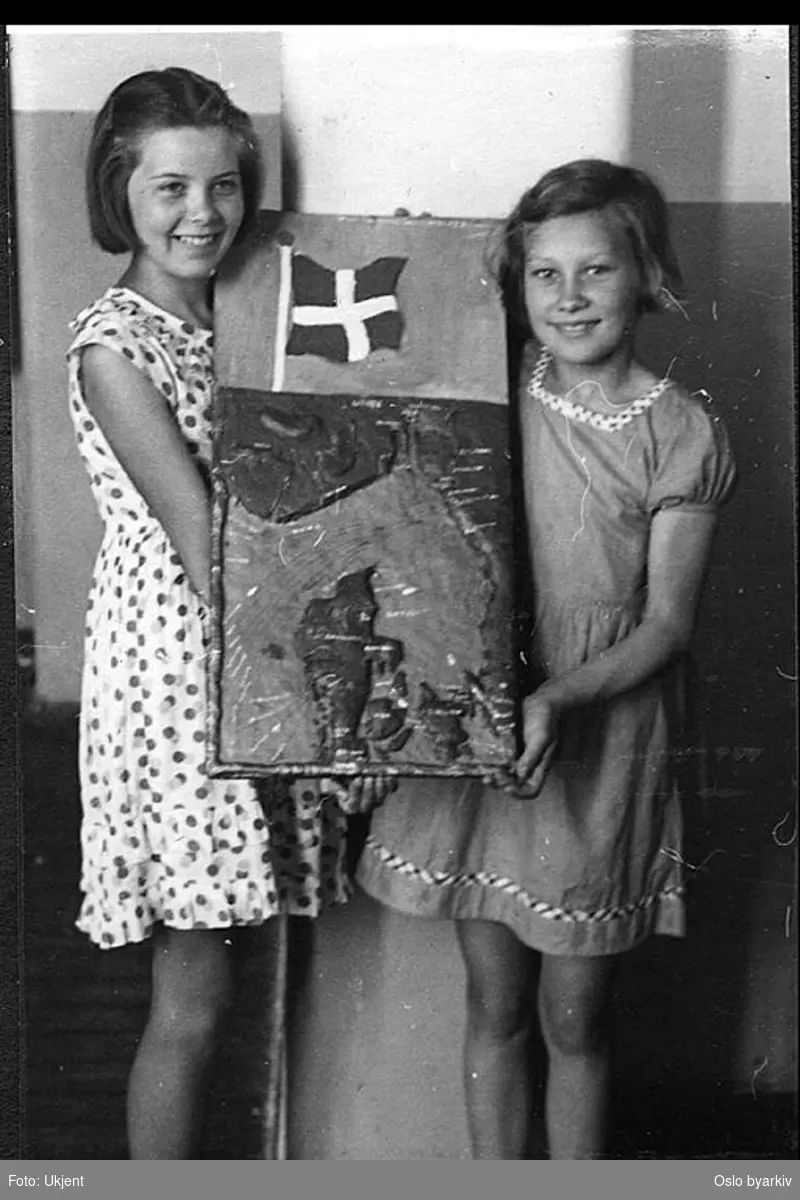 To jenter viser fram et relieffkart av Danmark. Albumtittel: "Sofienberg skole femti år - første september 1933."