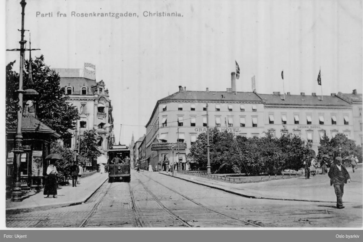 Rosenkrantz' gate med trikk. Eidsvolls plass, Narvesens aviskiosk / tårnkiosk på hjørnet mot Stortingsgata, Grand Hotel. Postkort