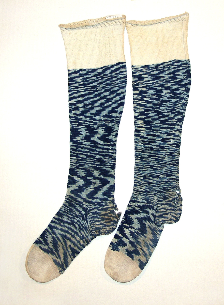 1 par sokker i bomull. Toppen, og tærne på sokkene er hvite, mens resten av sokkene er av melert flammegarn, som skaper mønster i lyst og mørkt blått.