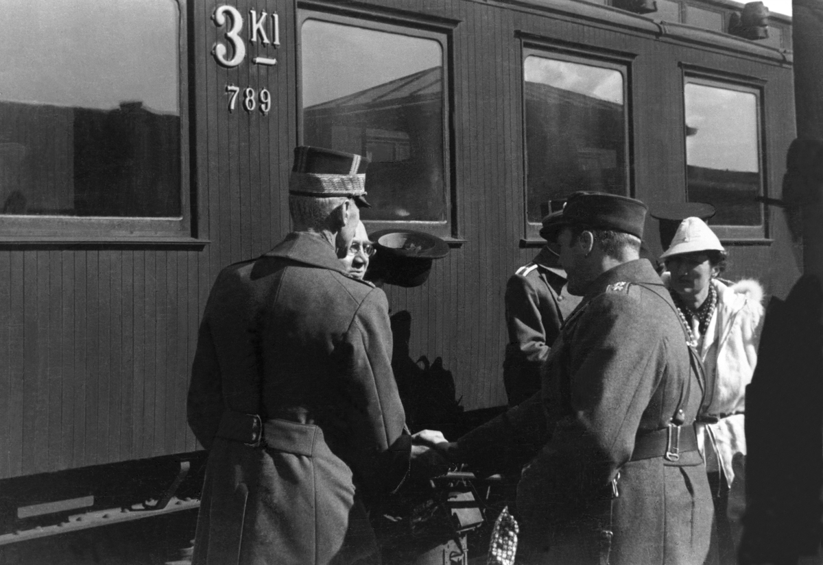Hamar stasjon, 9. april 1940. Kongefamilien og regjeringen ankommer jernbanestasjonen, Kong Haakon VII og kronprins Olav hilser på statsminister Johan Nygaardsvold, til høyre Kronprinsesse Märtha.