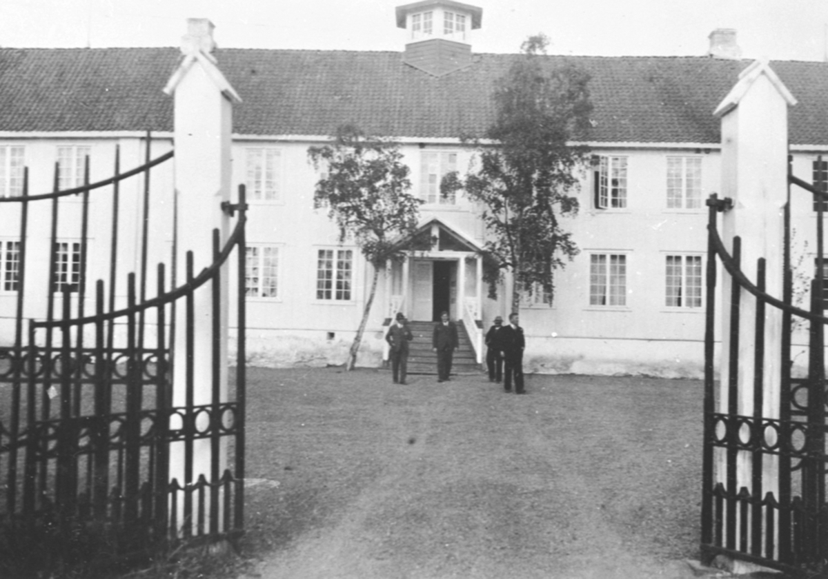 Inngangsparti på hovebygningen, Hovinsholm, Helgøya. 4 personer foran inngang.