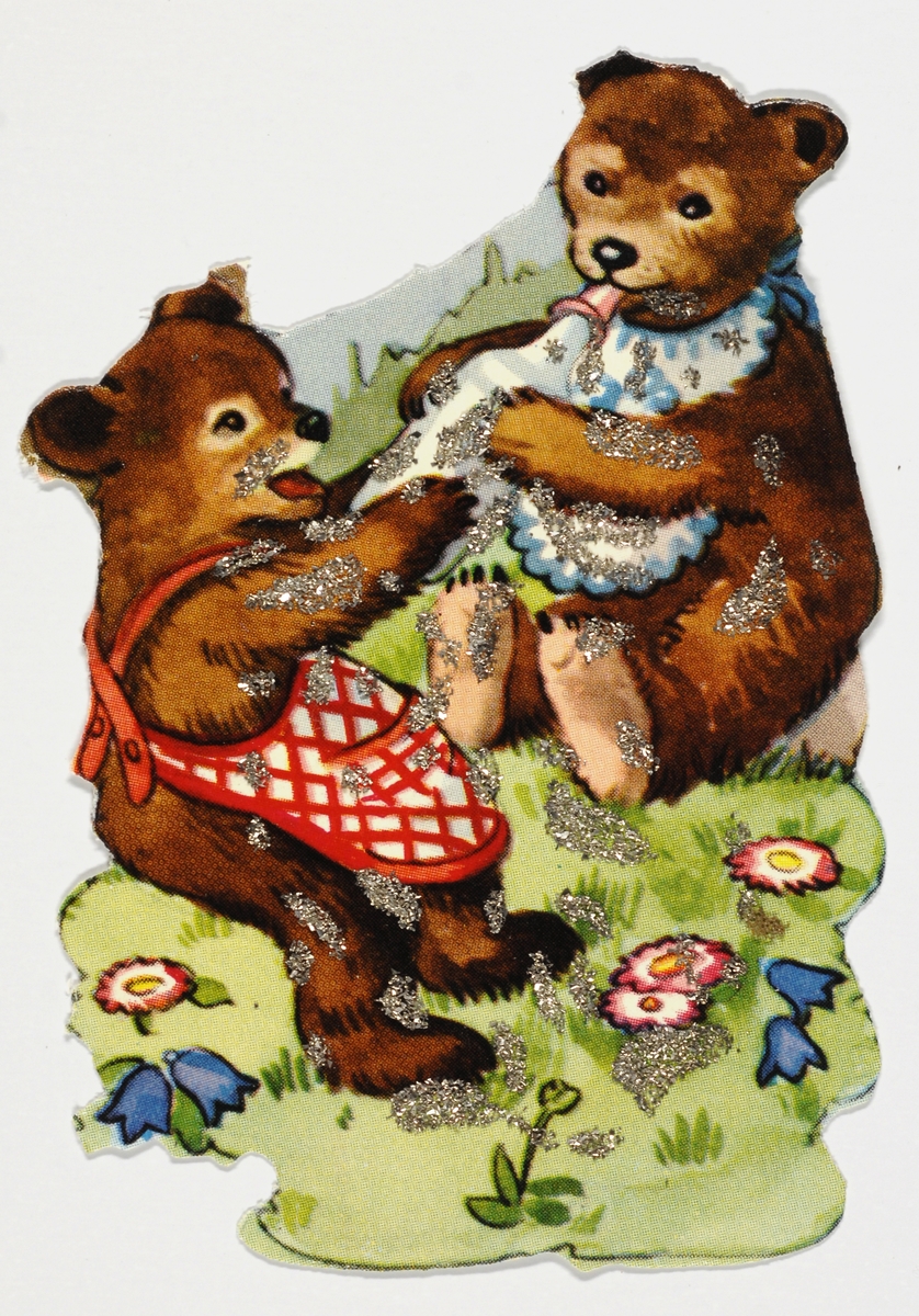 To bjørner sitter mot hverandre. Den ene holder en tåtflaske mot den andre bjørnen. De er påkledd med forkle og smekke.