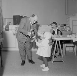 Jente får se på en samedukke, en av lotterigevinstene ved ju