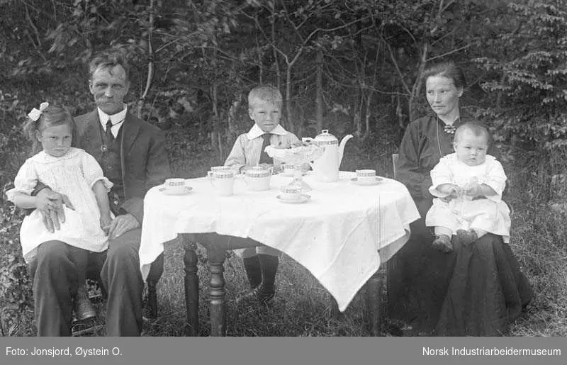 Familien Rognsjord samlet ved kaffebord i hagen.