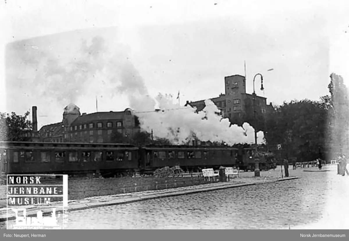 Damplokomotiv av type 23b foran et persontog på vei over Rådhusplassen