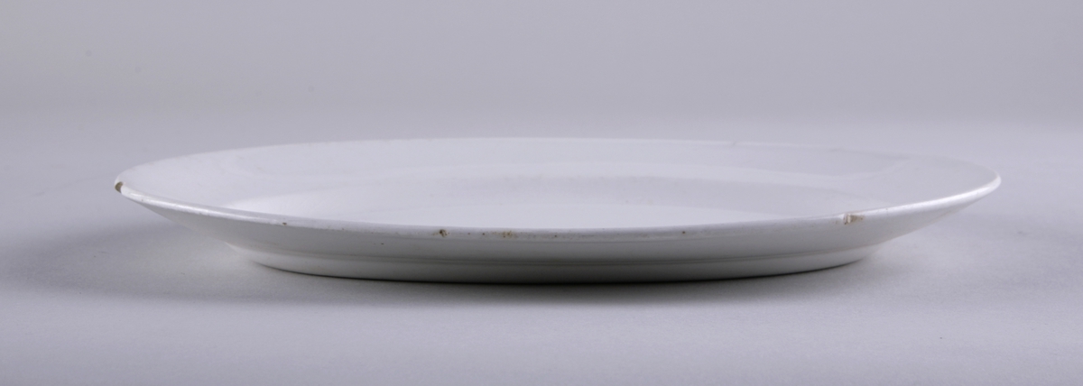 Ovalt serveringsfat i hvit keramikk.