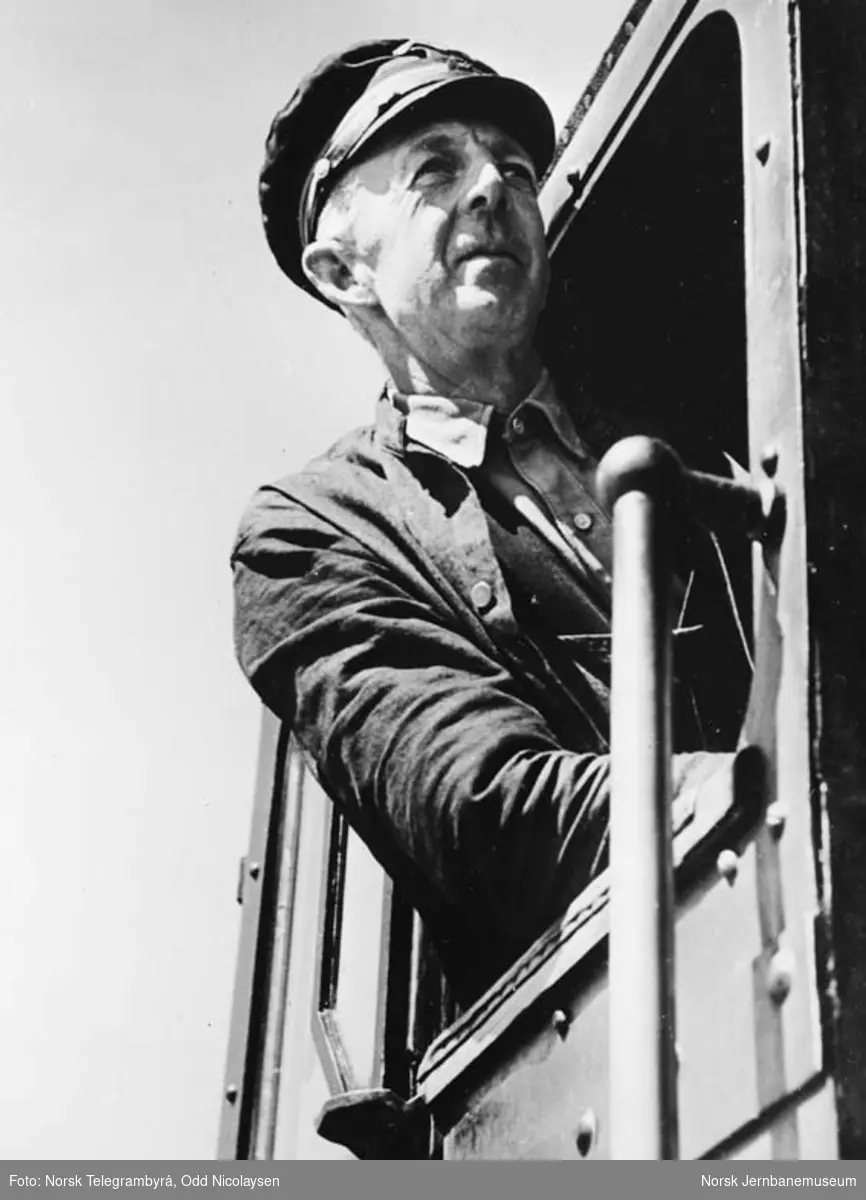 Lokomotivfører Kristian Alfr. Andersen i vinduet på et damplokomotiv