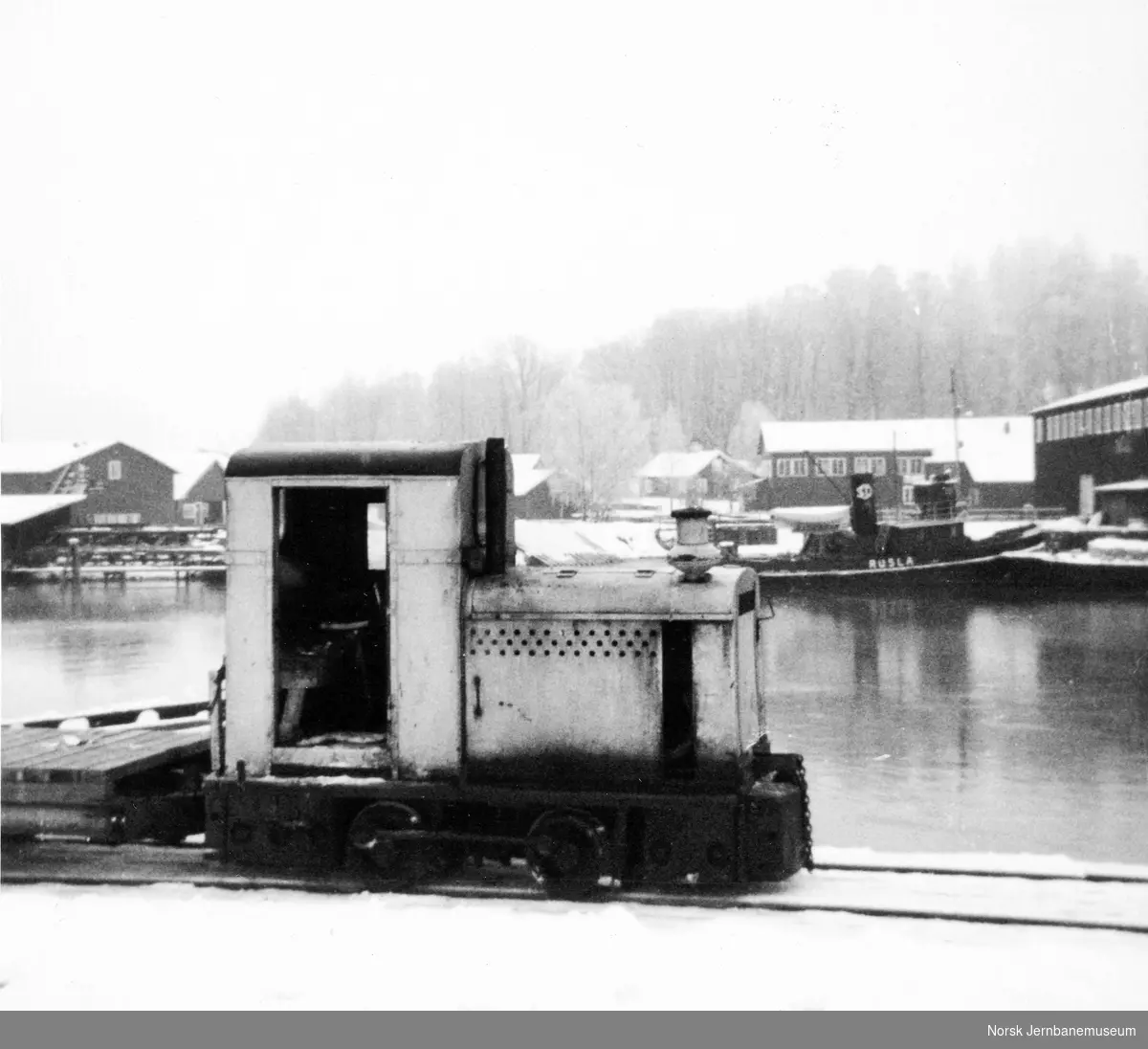 Diesellokomotiv på Aall-Ulefos Brug med slepebåten "Rusla" i bakgrunnen