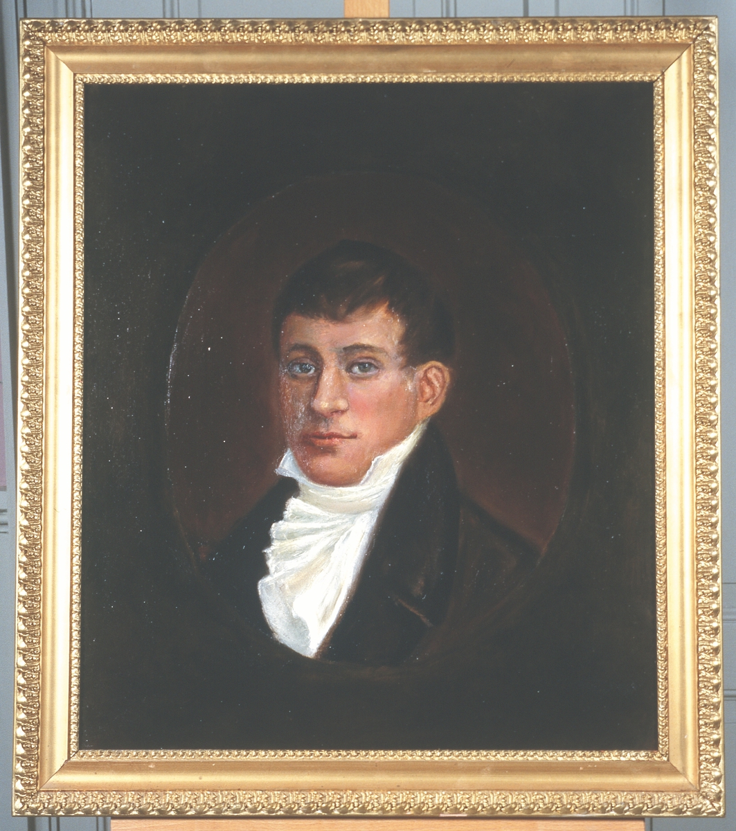 Portrett av eidsvollsmann Christopher F. Omsen.
Mann med kort, mørkt hår, mørk kledning og hvit skjorte med hvitt halsbind, kalvekryss
Innskrevet i oval.