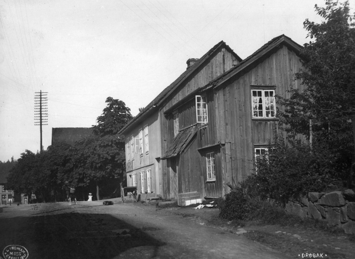 Storgata 22, Drøbak, Frogn, Akershus 1910. Gatebilde med gamle trehus.