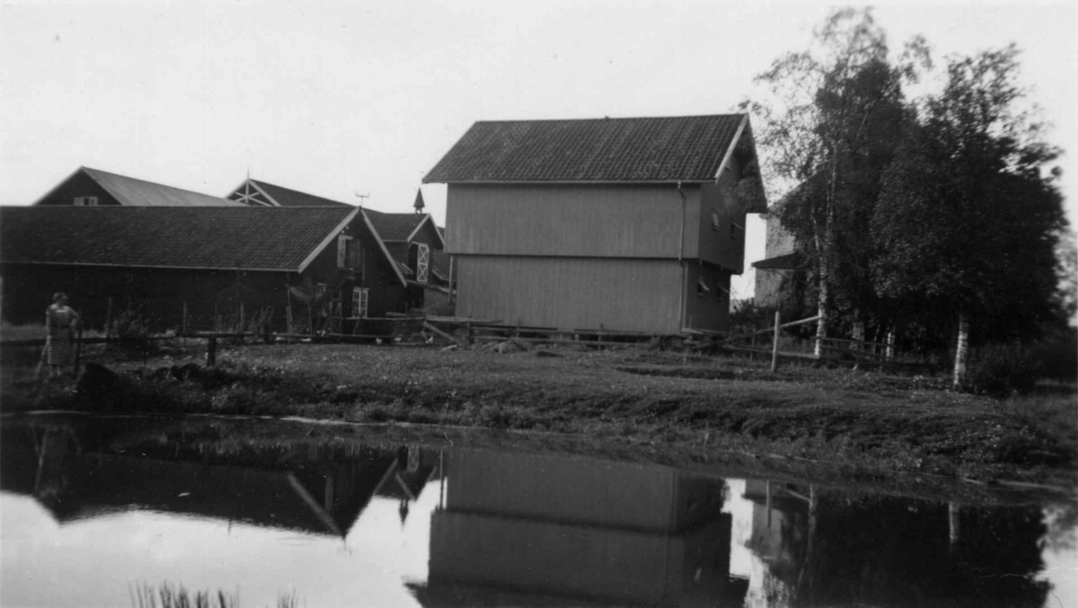 Østenbøl, Enebakk, Akershus 1937. Gårdsanlegget med dam i forgrunnen.